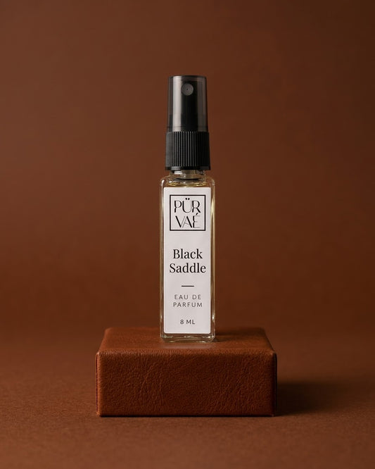 Black Saddle eau de parfum 8 ml glass spray on a cognac leather plinth