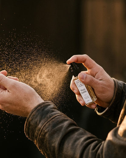 Hands spraying Black Saddle on the wrist