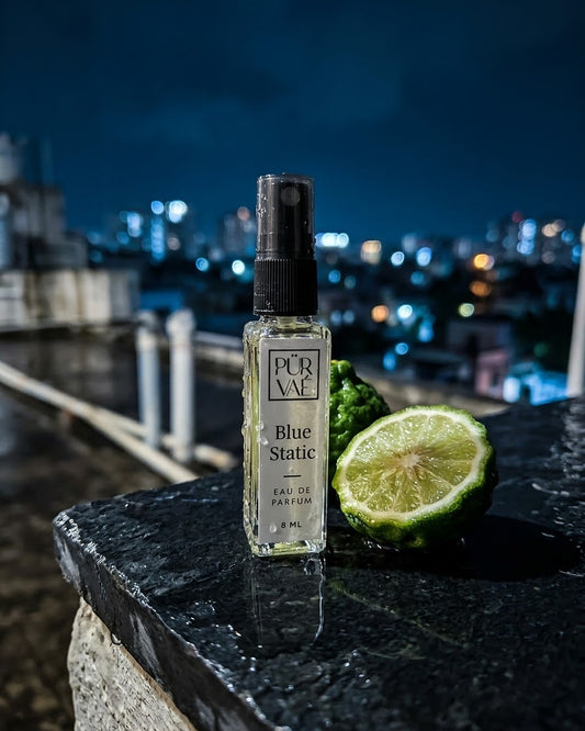 Blue Static on a wet rooftop ledge at night with a halved bergamot