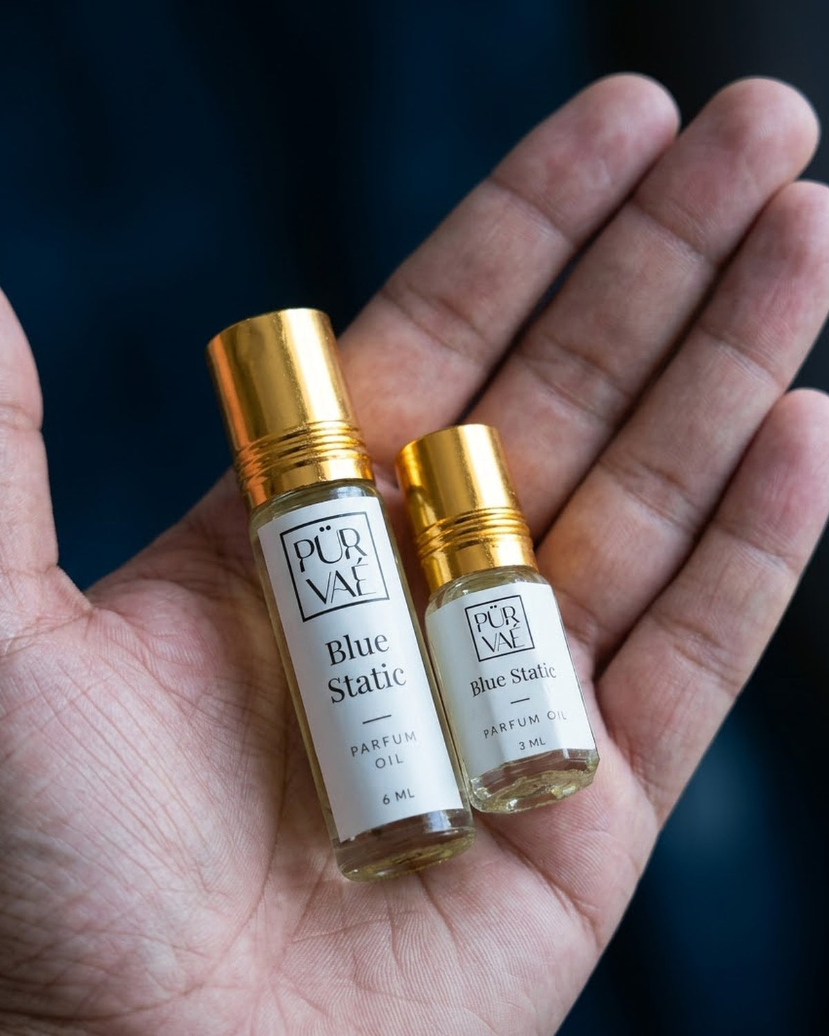 Blue Static parfum oil 6 ml and 3 ml held in one hand to show size