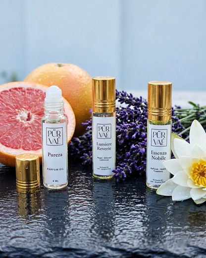 Purvae Day Trio: Pureza, Lumiere Reverie and Essenza Nobile 6 ml parfum oil roll-ons on wet dark stone with grapefruit, lavender and a water lily