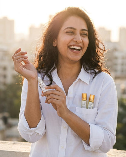 A woman laughing on a sunlit rooftop holding a Day Trio roll-on, two more in her shirt pocket