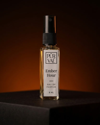 Ember Hour eau de parfum 8 ml glass spray on a dark plinth in ember-orange light