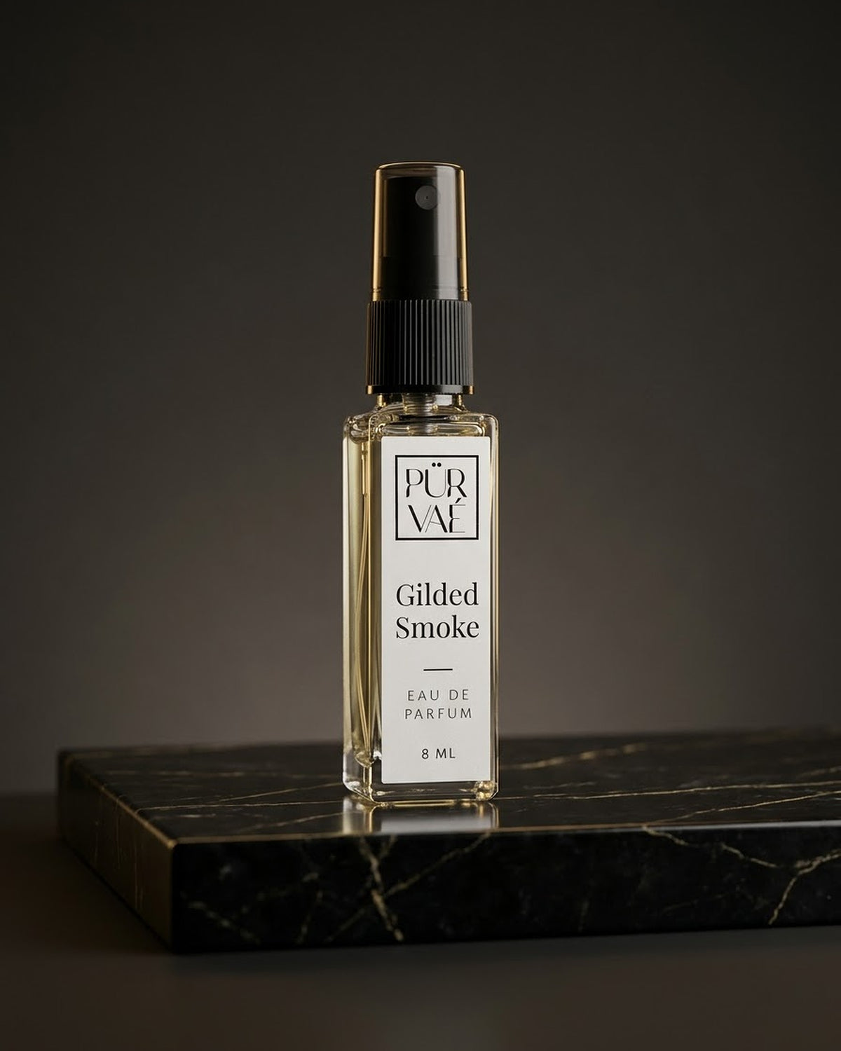 Gilded Smoke eau de parfum 8 ml glass spray on black and gold marble