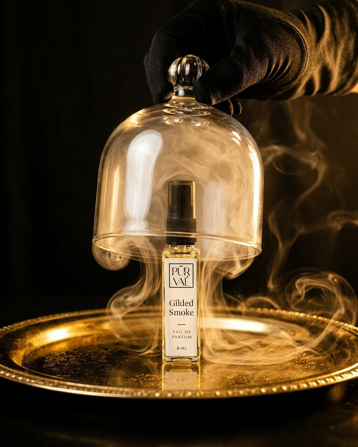 Gilded Smoke revealed under a glass cloche with smoke on a gold tray