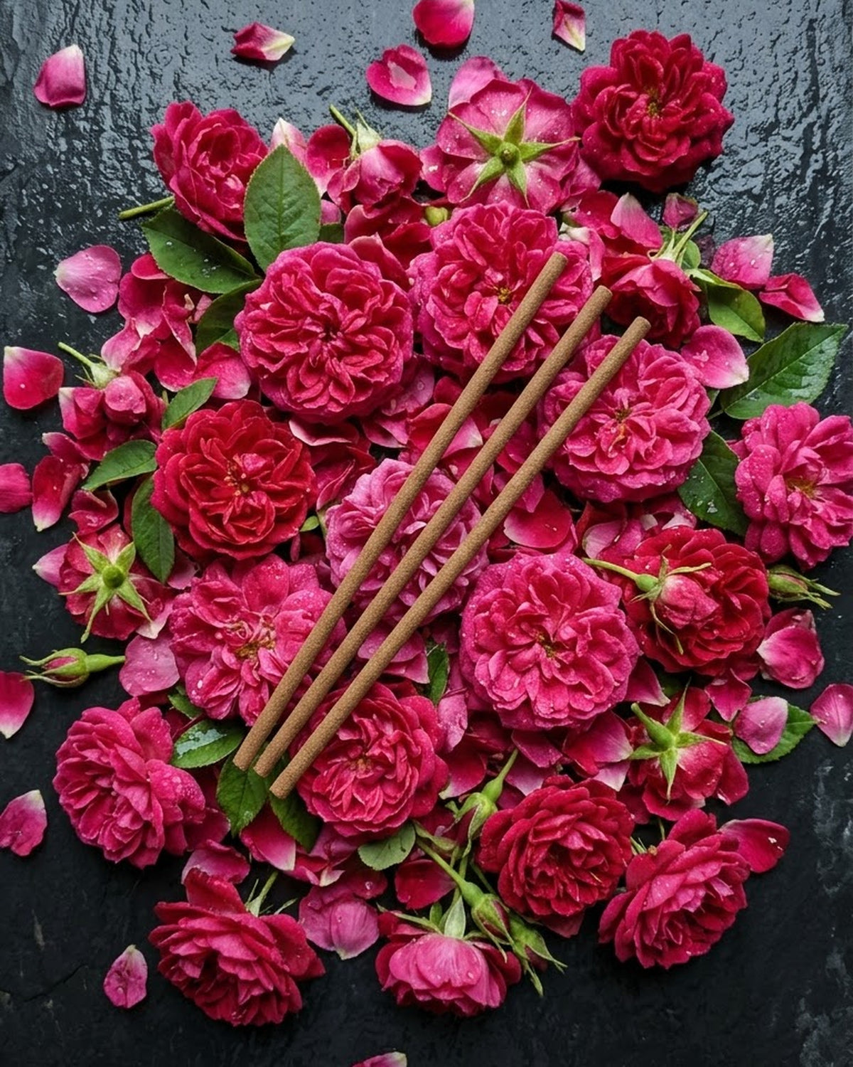 Desi gulab (damask rose) heads and petals that inspire Gul Aangan dhoop sticks, with three unlit long sticks