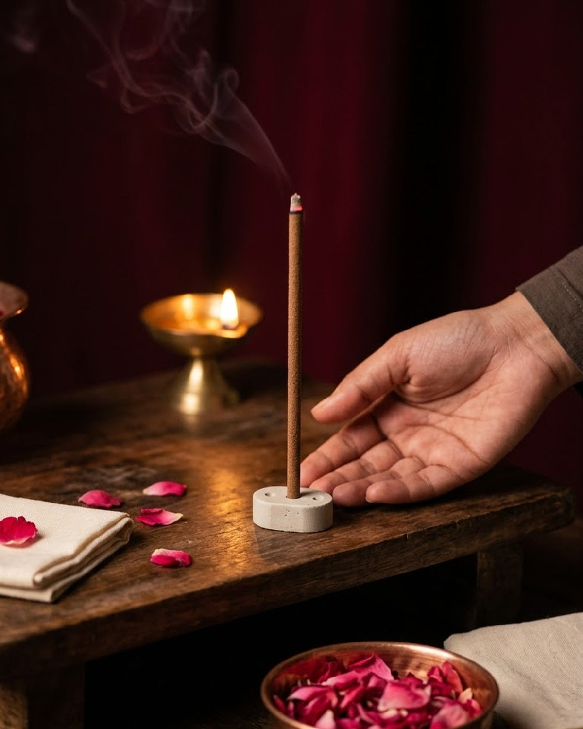 Gul Aangan dhoop stick burning at a puja corner with a brass diya and a bowl of rose petals