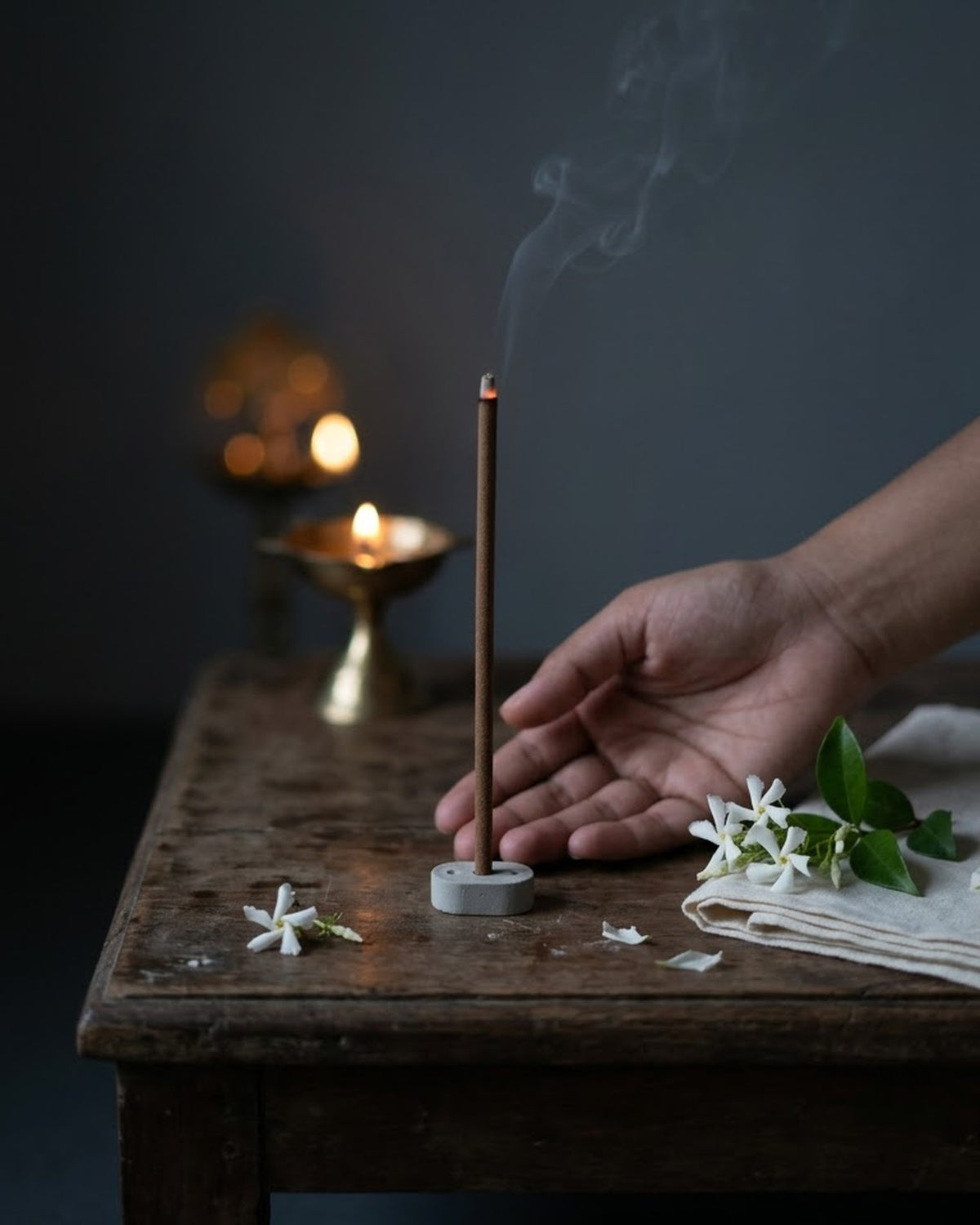 Jasmine Lehar dhoop stick burning at a puja corner with brass diyas and jasmine sprays