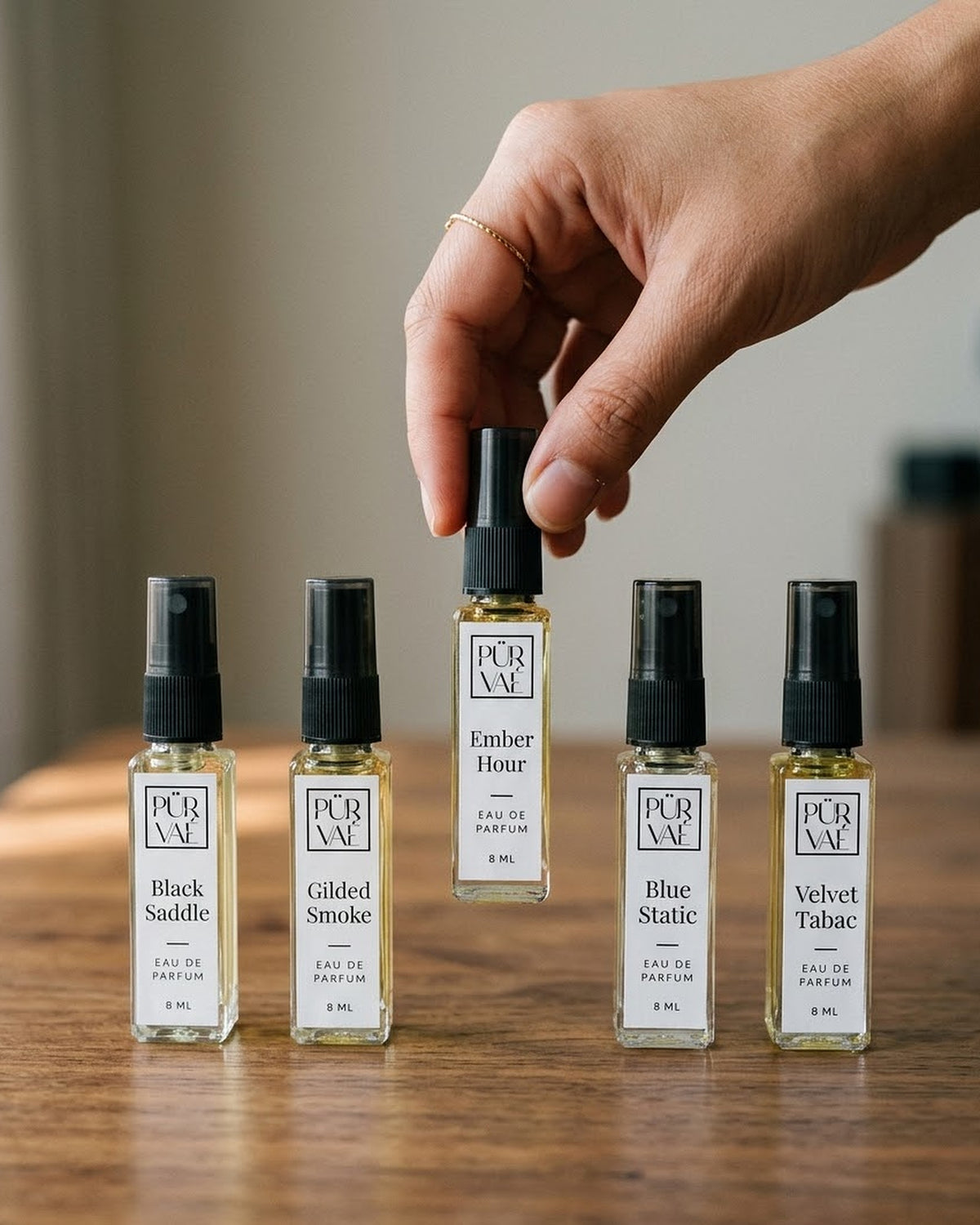 A hand choosing Ember Hour from the five Root Five bottles