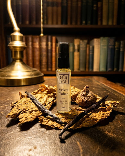 Velvet Tabac on a library desk with tobacco leaves and vanilla pods