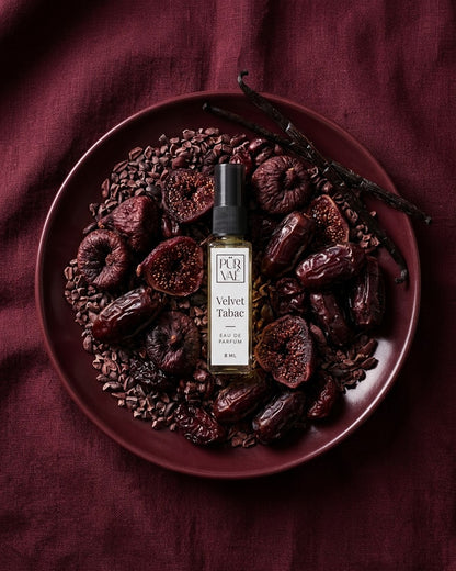 Velvet Tabac on a burgundy plate of dried figs, dates and cacao nibs