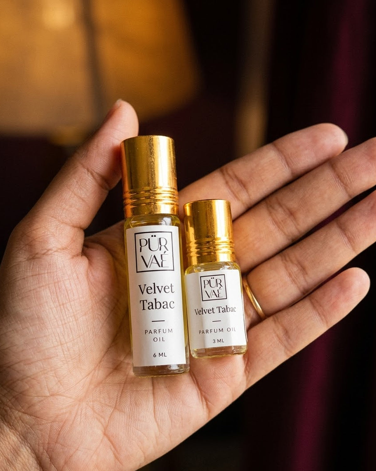 Velvet Tabac parfum oil 6 ml and 3 ml held in one hand to show size